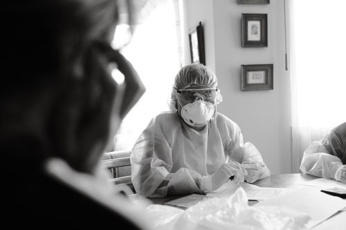 Free A black and white image of healthcare workers wearing protective suits and masks indoors. Stock Photo