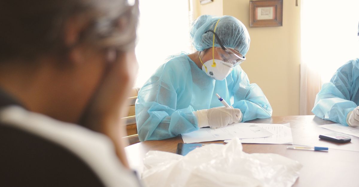 Hispanic family reviewing healthcare documents with a social worker at a community health clinic