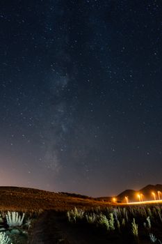 A stunning view of the Milky Way over a quiet rural area at night.