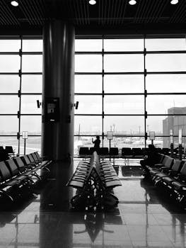 Serene view of an empty airport terminal with seating and window view of the runway.