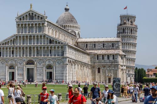 Free Crowds explore the Pisa Cathedral and iconic Leaning Tower on a sunny day in Pisa, Italy. Stock Photo
