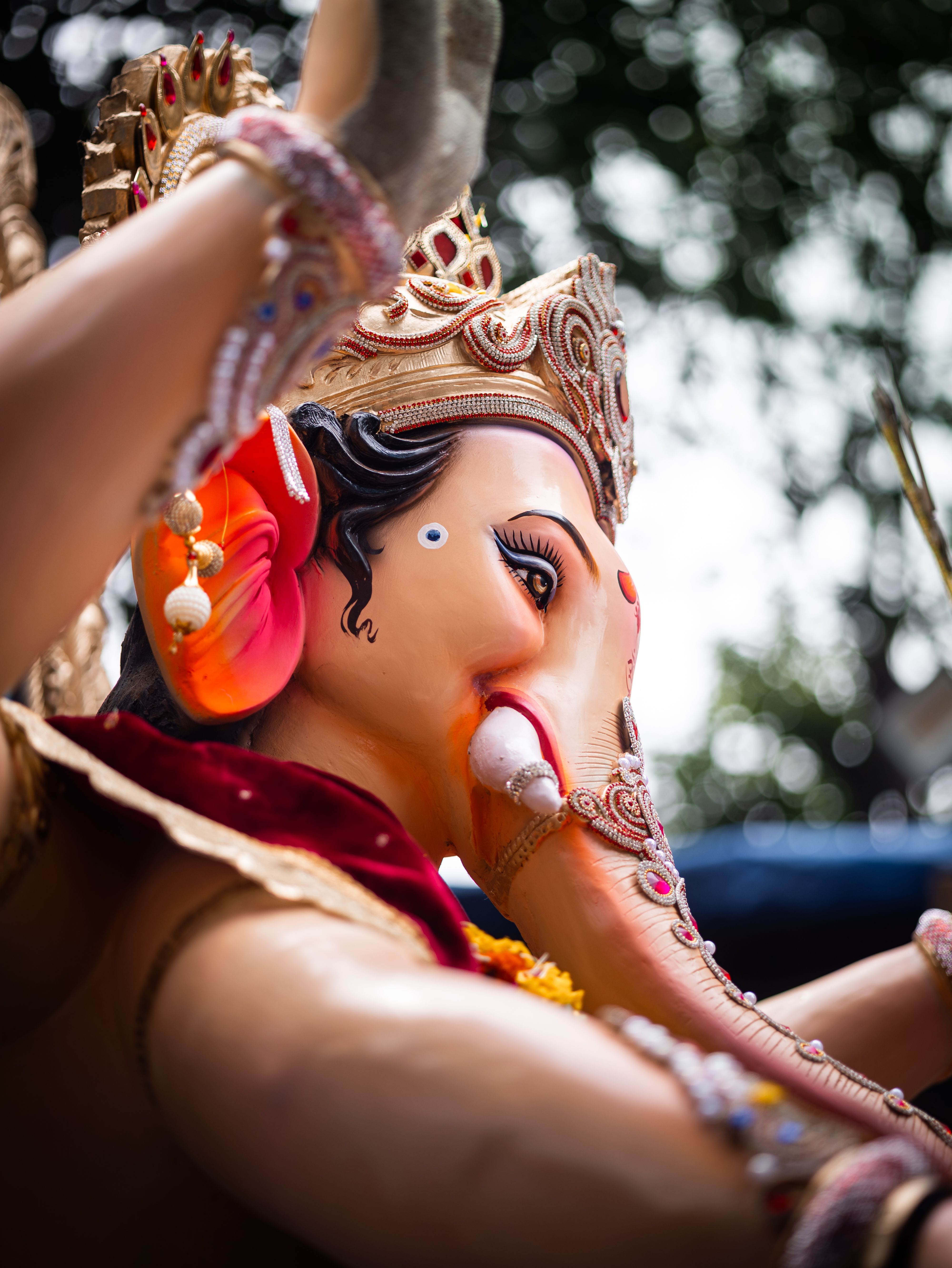 Detailed close-up of a beautifully crafted Ganesh idol with vibrant colors and intricate ornaments.