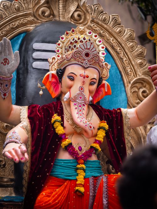Free Intricately designed Ganesha idol adorned with flowers at a colorful festival. Stock Photo