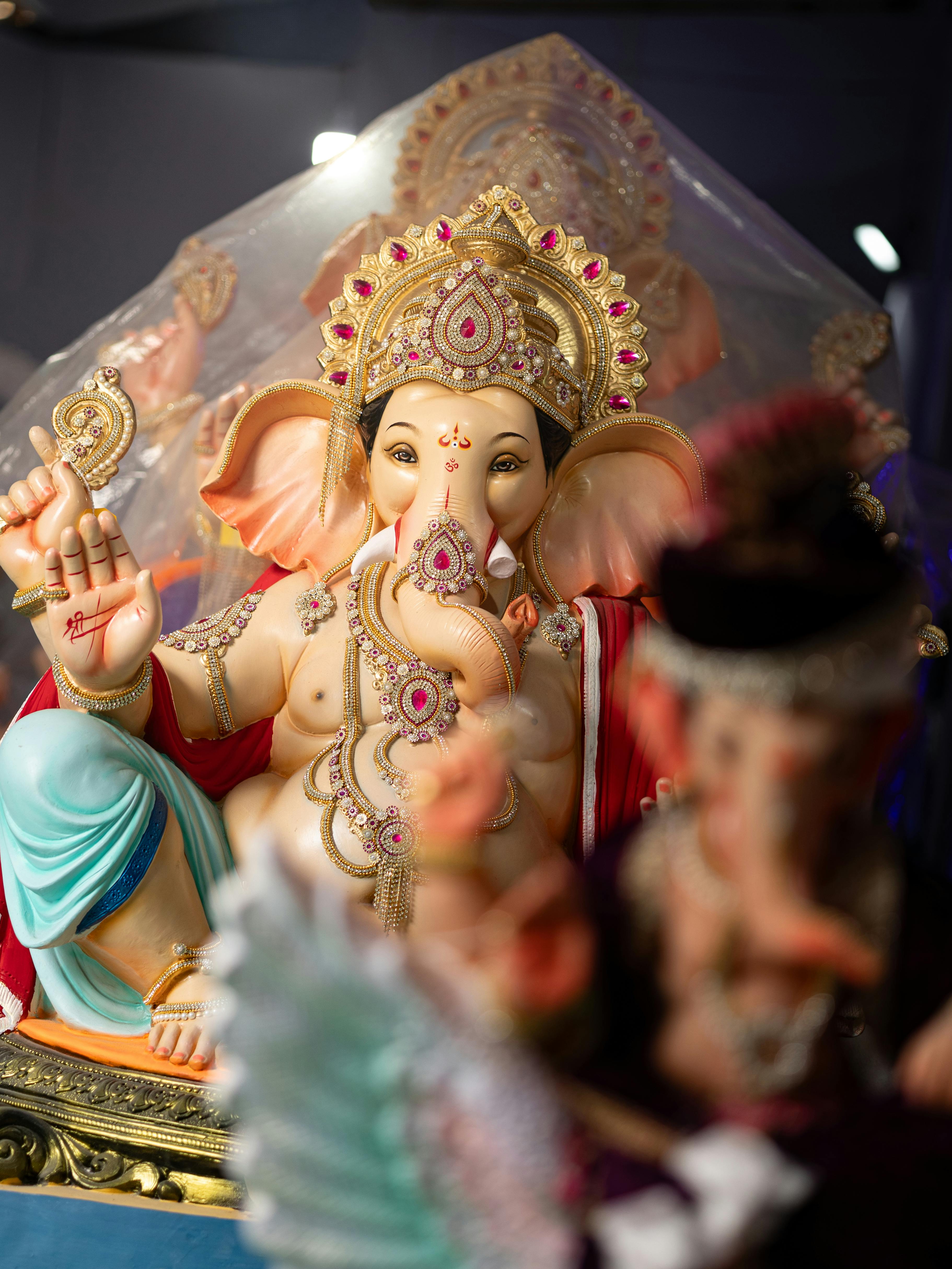 Colorful statue of Lord Ganesh adorned with jewels and intricate designs.