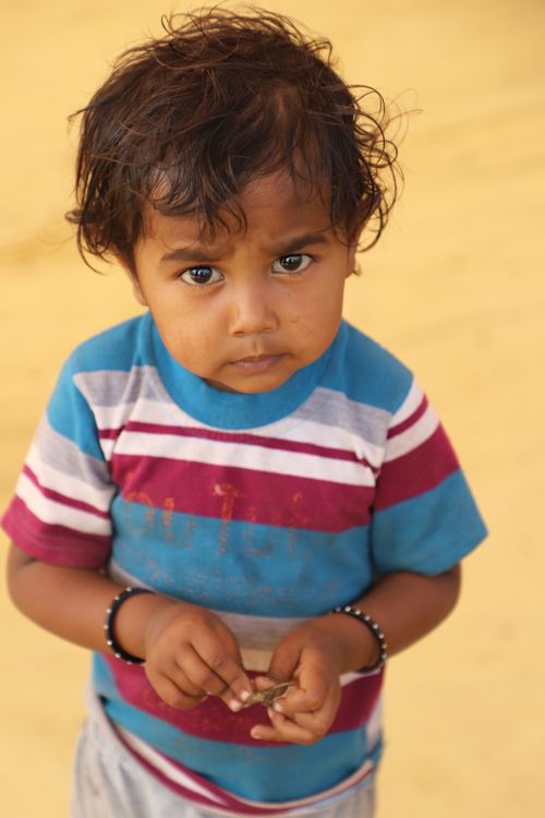 Free A young child with expressive eyes captured outdoors in Dhari, Gujarat, India. Stock Photo