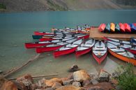 Vibrant canoes lined up on a serene lake in Canada, perfect for summer adventures.