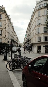Paris street scene featuring bicycles, classic architecture, and people strolling.