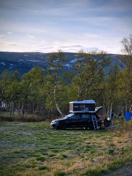 Overland vehicle with roof tent at mountain campsite