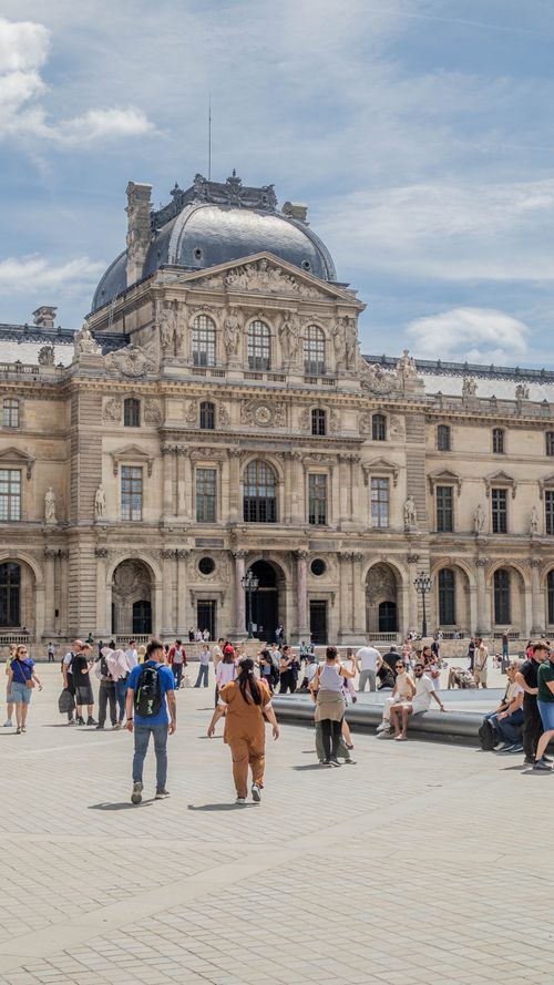Free People enjoy a sunny day outside the historic Louvre Museum in Paris. Stock Photo