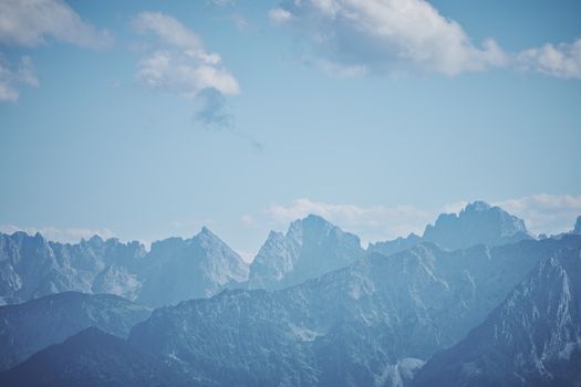 A breathtaking view of the Bavarian Alps in Samerberg, Germany, showcasing mountain peaks against a clear blue sky.