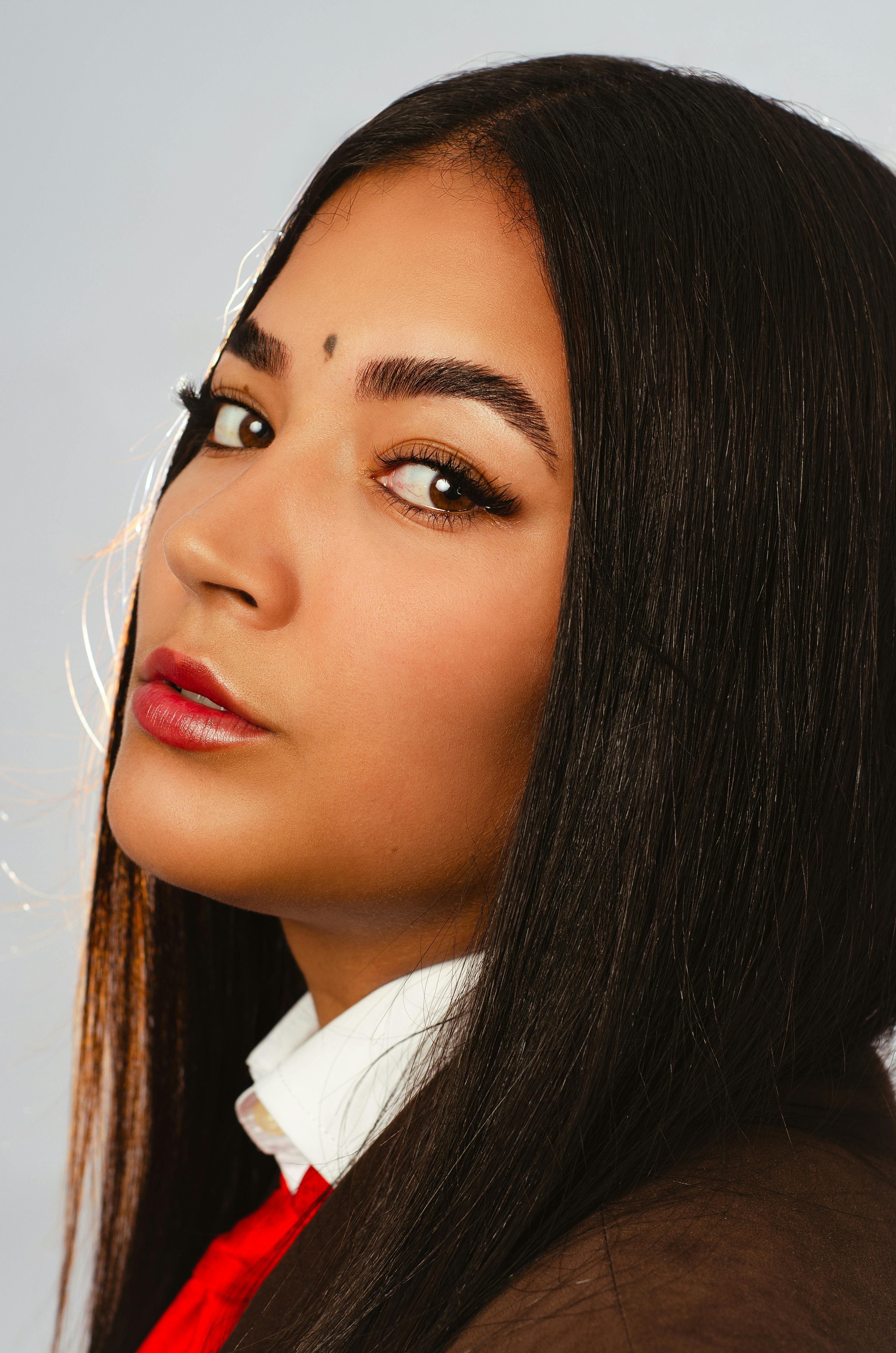 Close-up portrait of a young woman with long dark hair and a confident expression.