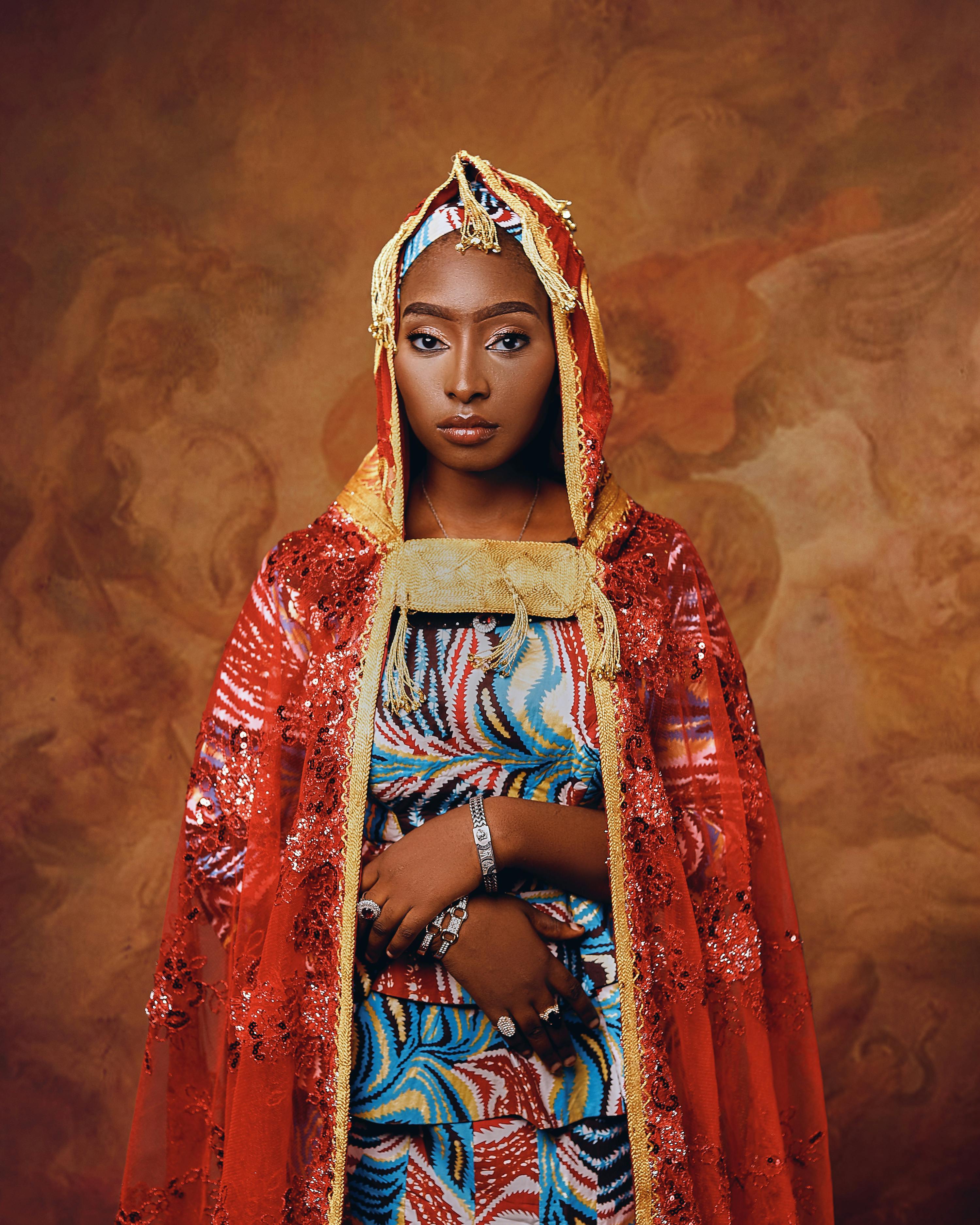 Elegant woman in colorful traditional garment with intricate patterns and a rich background.
