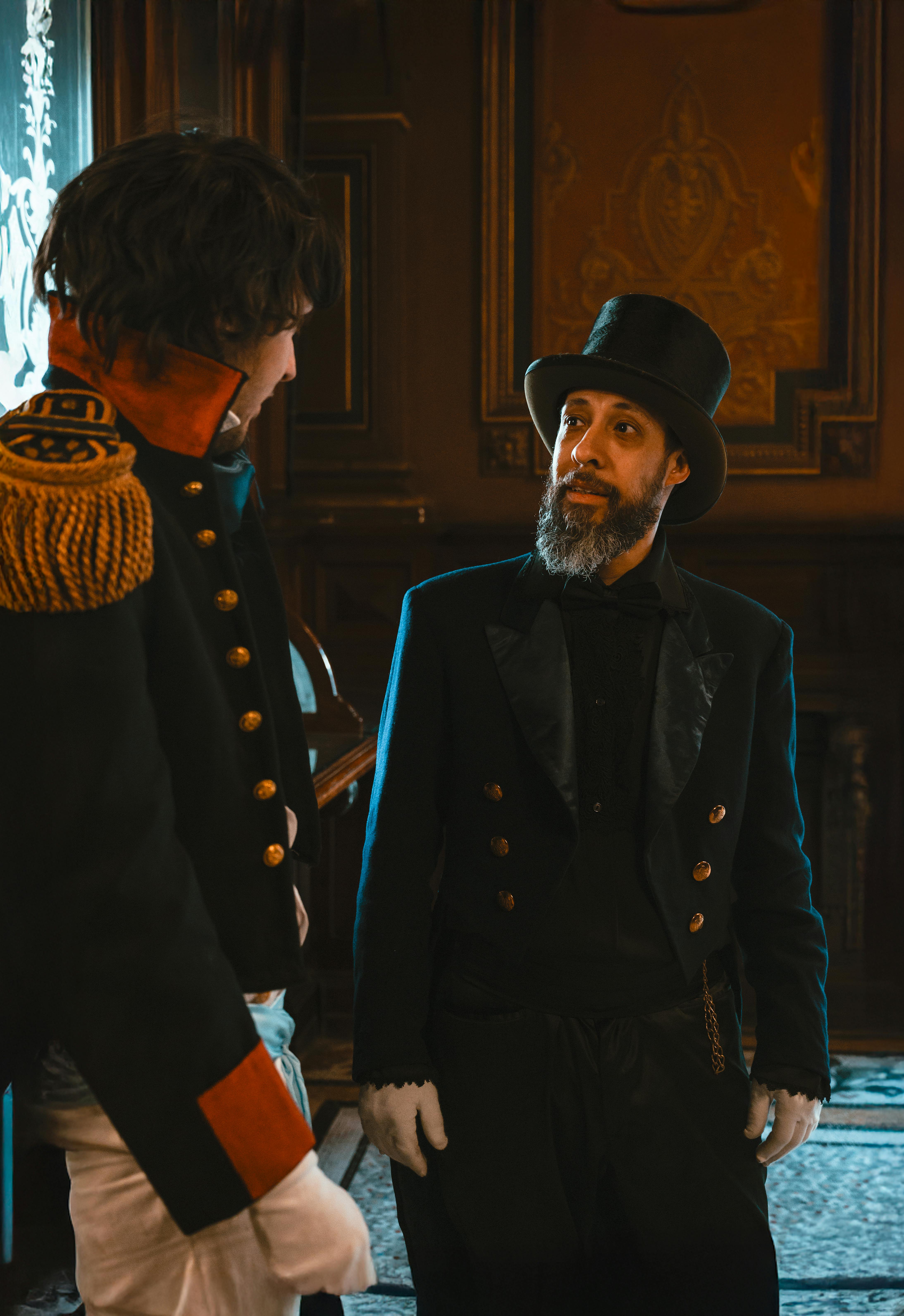 Free Men in period costumes having a conversation indoors, Buenos Aires. Stock Photo