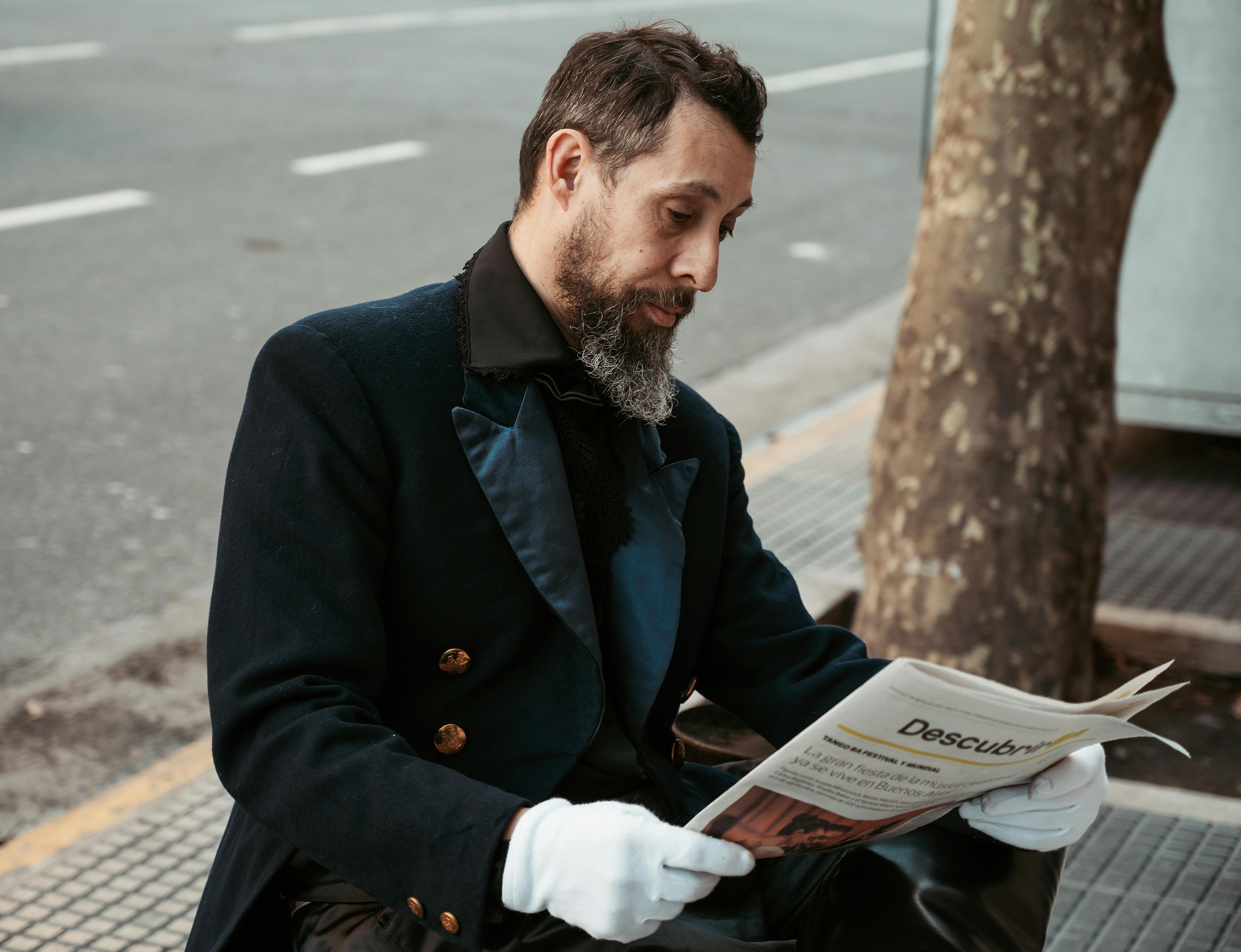 grátis Um homem sentado em uma rua de Buenos Aires, profundamente envolvido com um jornal, refletindo sobre a vida cotidiana na Argentina. Foto profissional