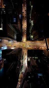 Stunning aerial view of a bustling city intersection at night with glowing streetlights and towering buildings.