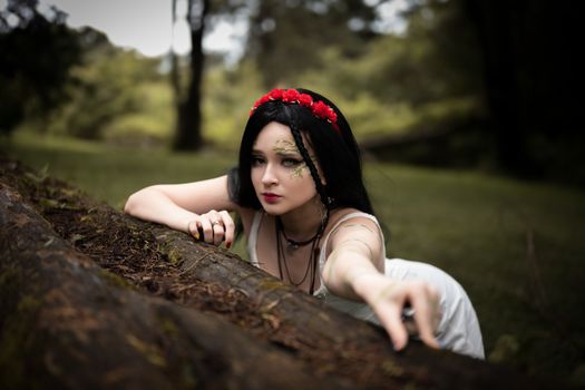Mystical woman in forest setting, blending fantasy and reality with earthy tones.
