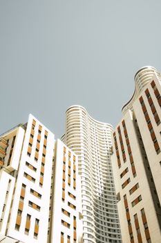 Contemporary architecture featuring high-rise buildings with a unique wavy design against a clear sky.