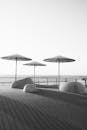 极简主义的沿海长廊，黑白色调，雨伞作为点缀
