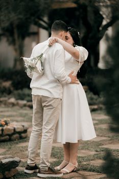 A loving couple shares a tender moment at an outdoor wedding ceremony.