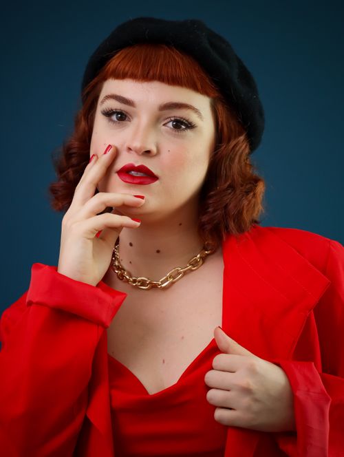 Free Portrait of a stylish woman in a red outfit with a black beret, exuding confidence. Stock Photo