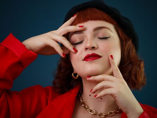 Free Close-up portrait of a fashionable woman in red attire, with red nails and accessories. Stock Photo