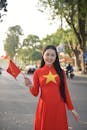 Woman in Red Ao Dai Holding Vietnamese Flag