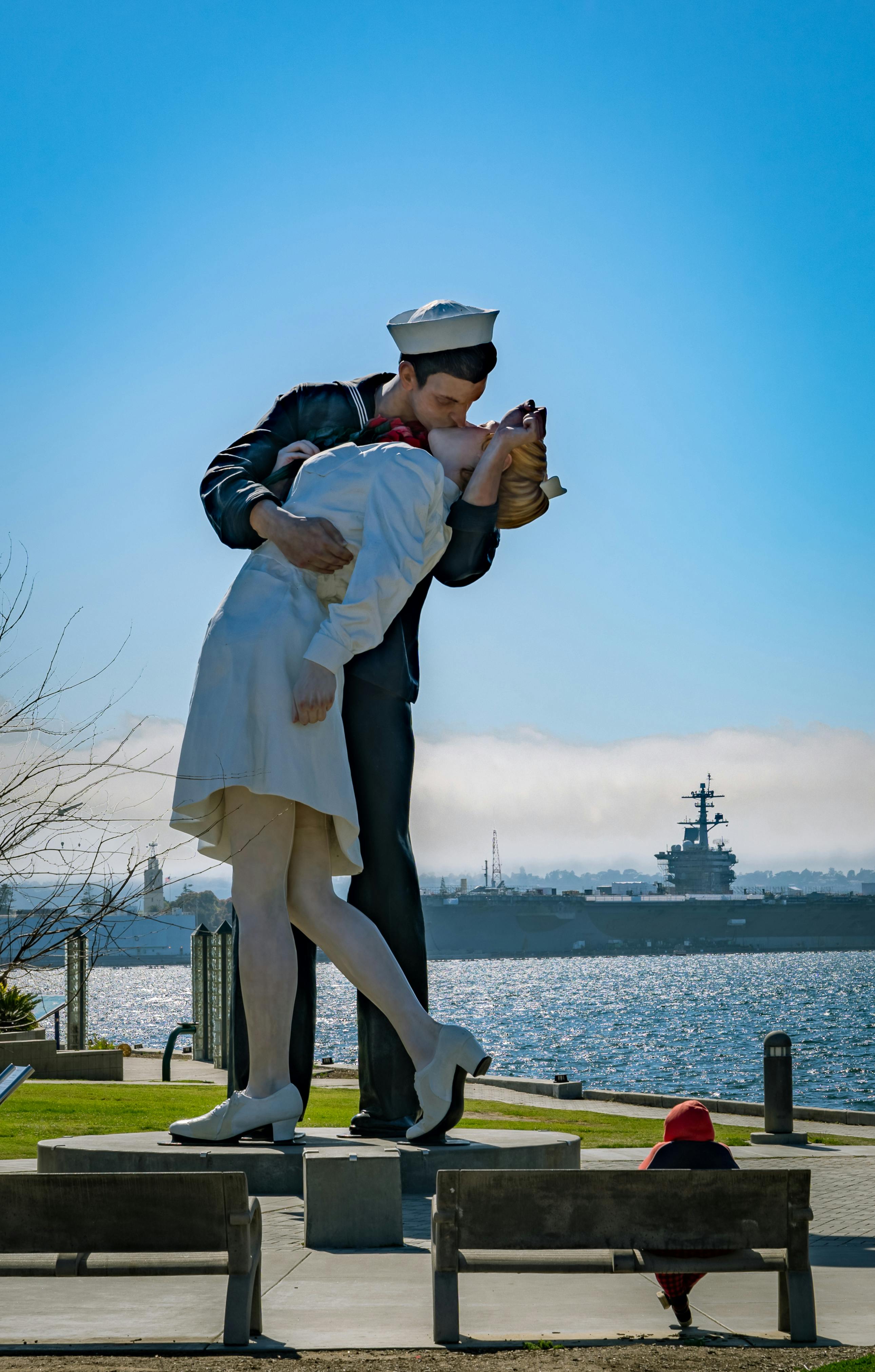 Captivating view of the Unconditional Surrender Statue in San Diego with naval base in background.