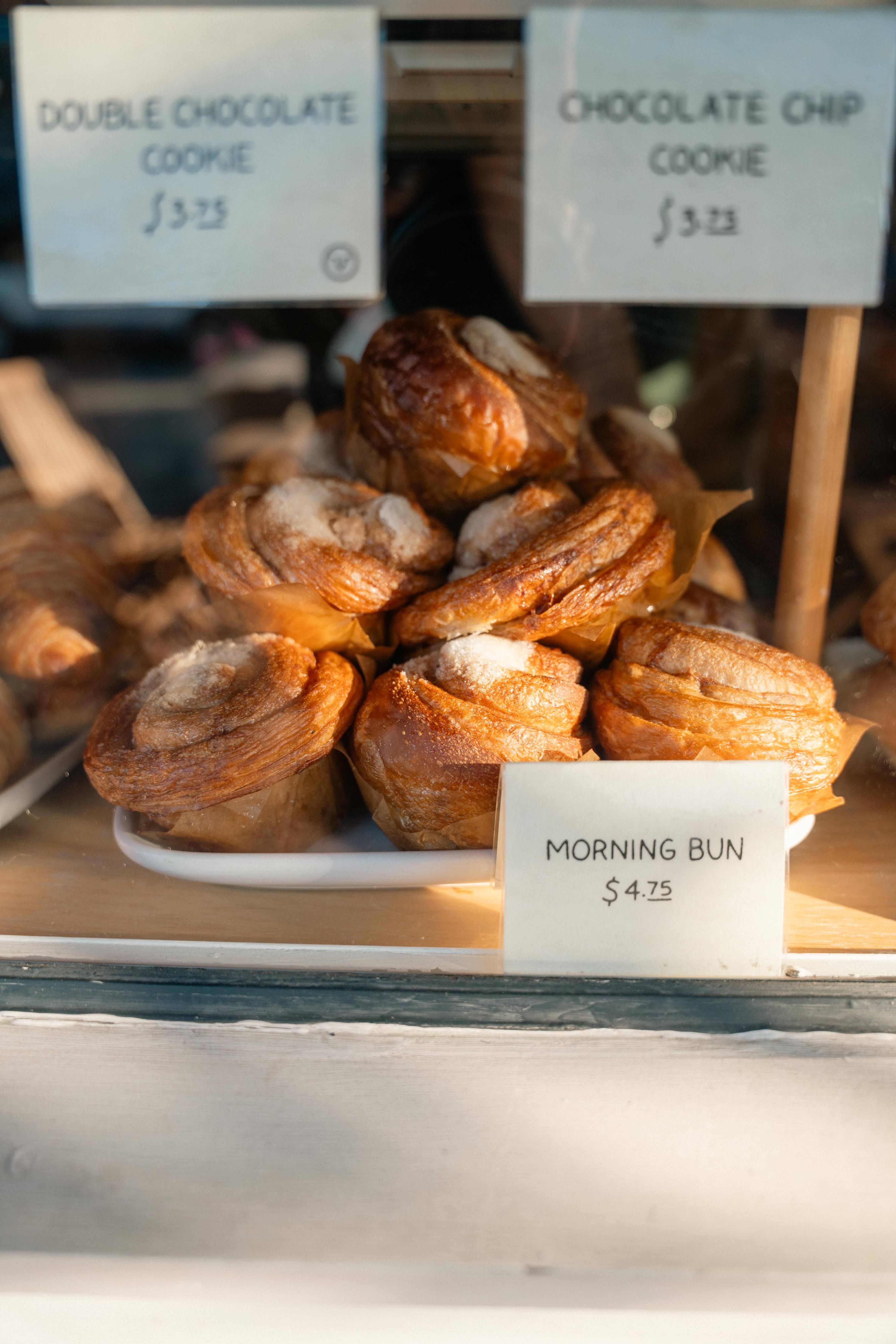 Freshly baked morning buns with cinnamon sugar on a bakery display tray