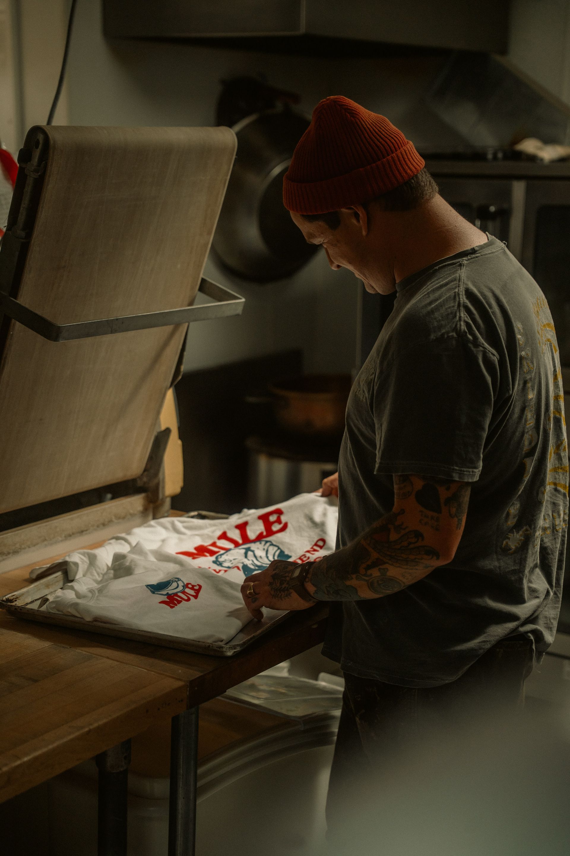 Artist screen printing a t-shirt in a workshop