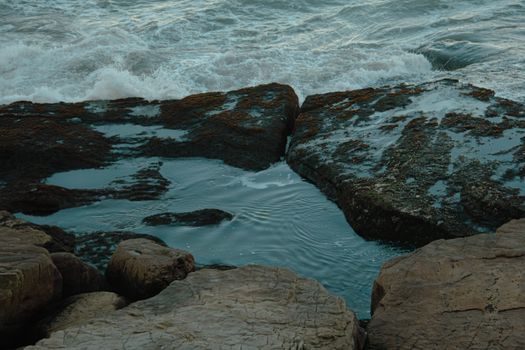 Tranquil scene of rocky seashore with tidal pool and gentle waves, perfect for nature lovers.. pexels, tranquil, scene