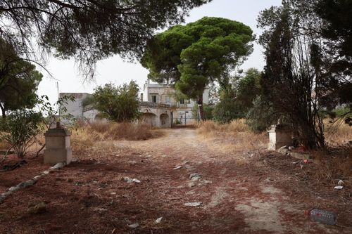 Free Explore an abandoned historic building surrounded by lush trees in El Puerto de Santa María. Stock Photo