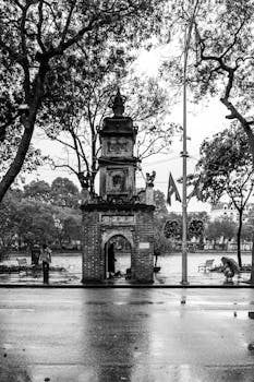 Moody black and white photo of an ancient gate in Hanoi, Vietnam after a rain shower.