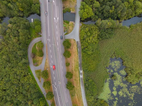 Aerial photograph capturing a scenic highway surrounded by lush greenery and bodies of water in Jönköping, Sweden.