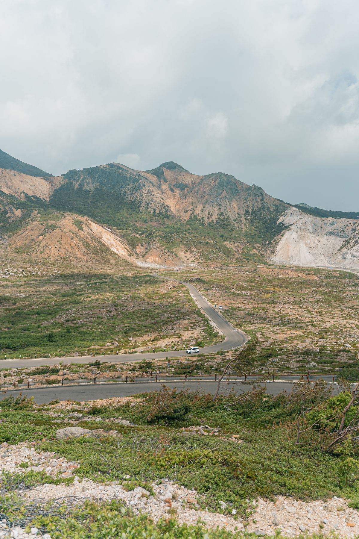 A mountain road winding across volcanic highlands in the Inawashiro area of Fukushima