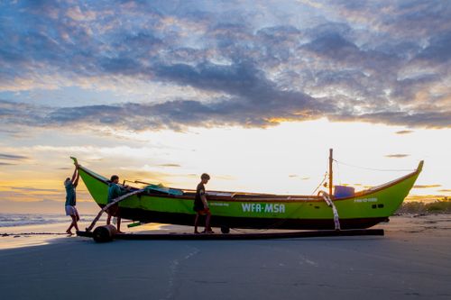 Free Traditional green boat at sunset on a beach in Ilocos Region, Philippines. Stock Photo