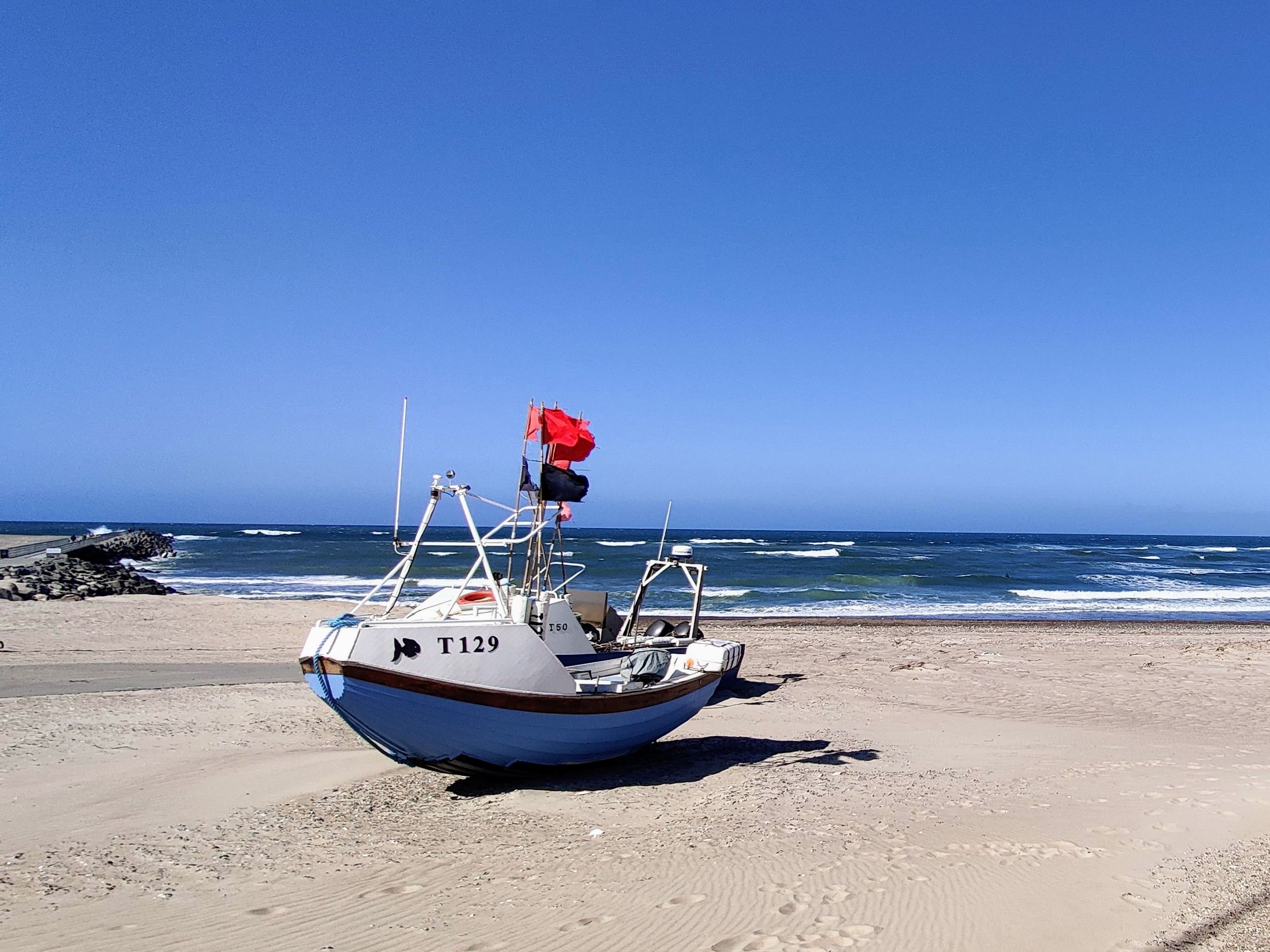 A fishing boat rests on a beach