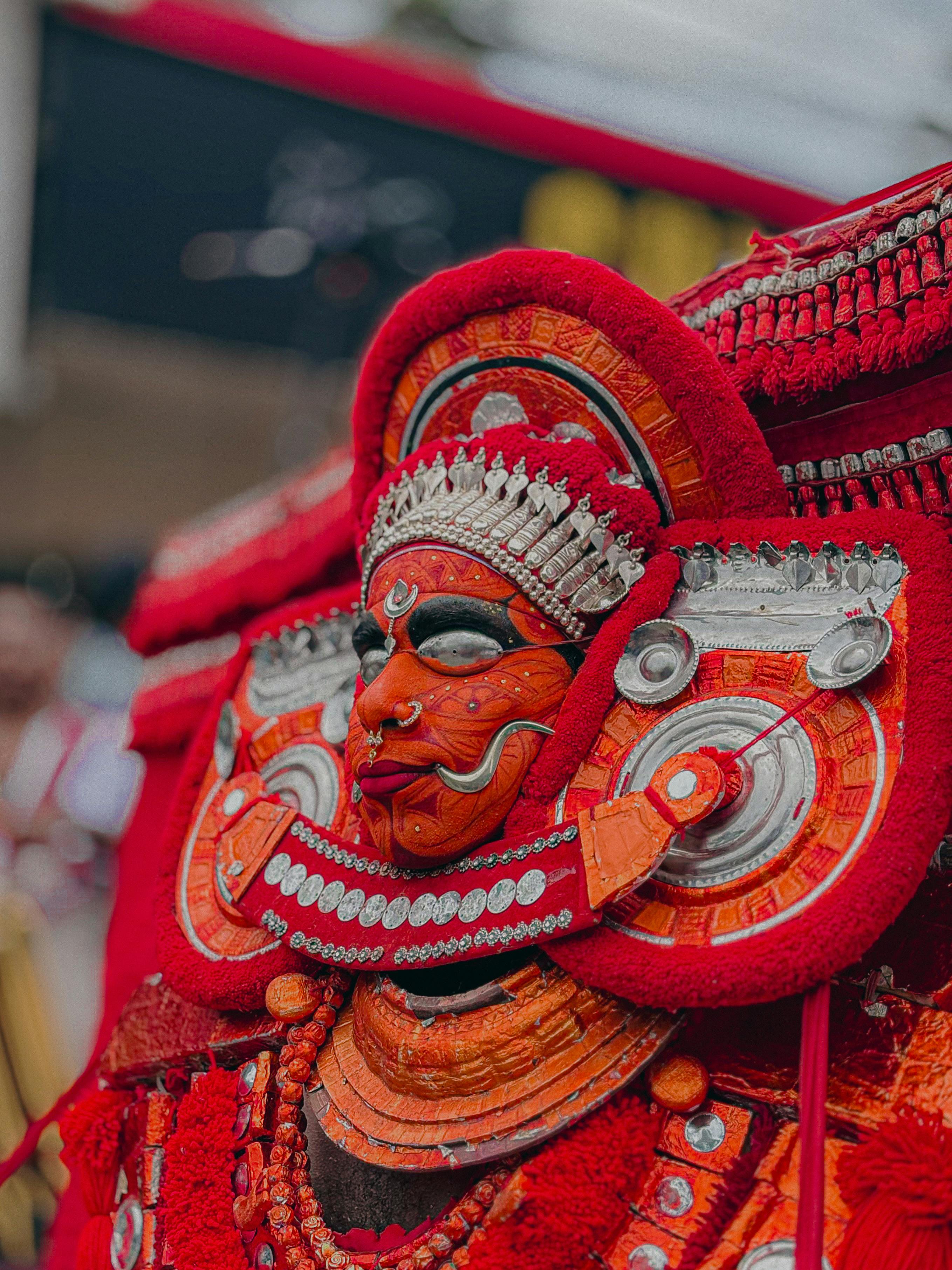 Theyyam performer in vibrant red attire