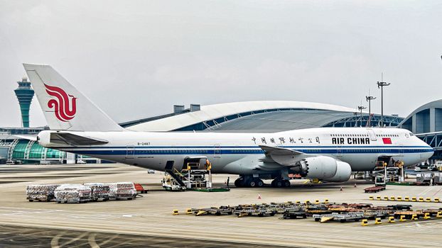 Air China Boeing 747-8 at airport terminal with cargo loading.
