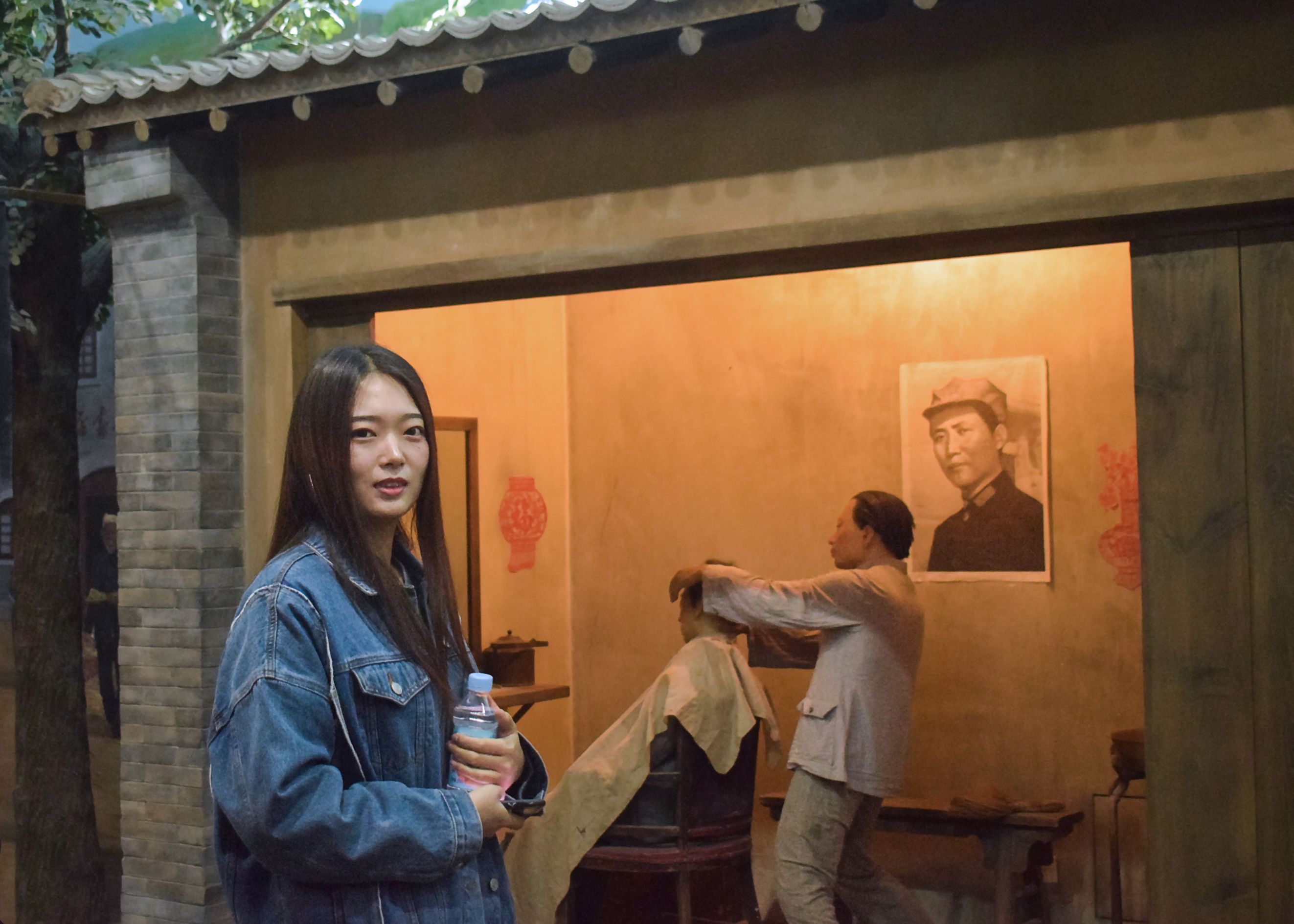 Yunnan street barber with customer, young woman holding bottle.