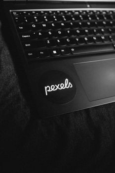 Close-up of a laptop keyboard in monochrome with Pexels sticker visible.