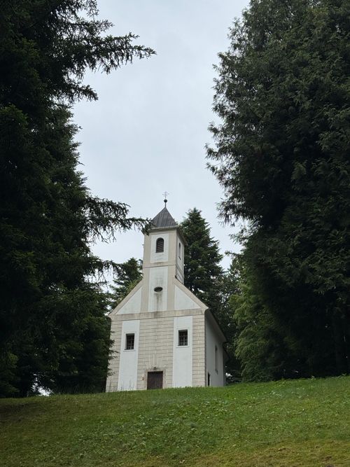 Free A quaint white chapel surrounded by greenery in Trakošćan, Croatia. Perfect for serene travel photography. Stock Photo