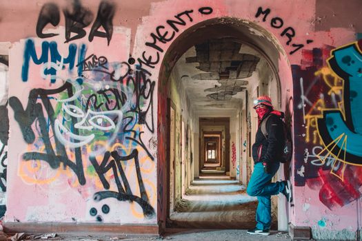 Exploring vibrant graffiti in a deserted Swiss building corridor.