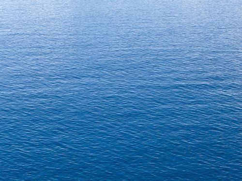Free A serene view of the blue ocean surface, capturing the tranquility and endless horizon. Stock Photo