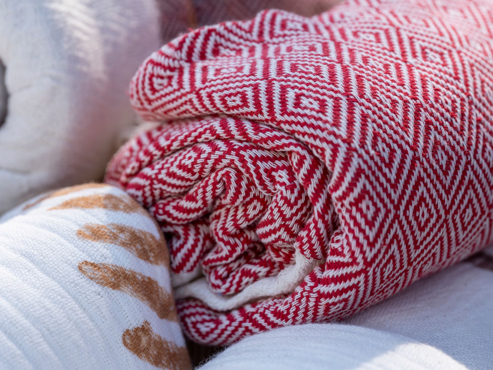 Colorful rolled towels featuring intricate geometric designs, ideal for home decor or gifts.