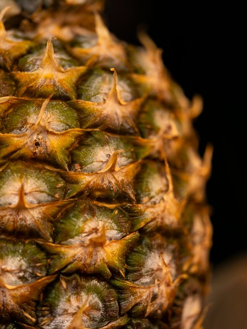 Free Detailed close-up of a pineapple's textured skin highlighting its vibrant, tropical surface. Stock Photo