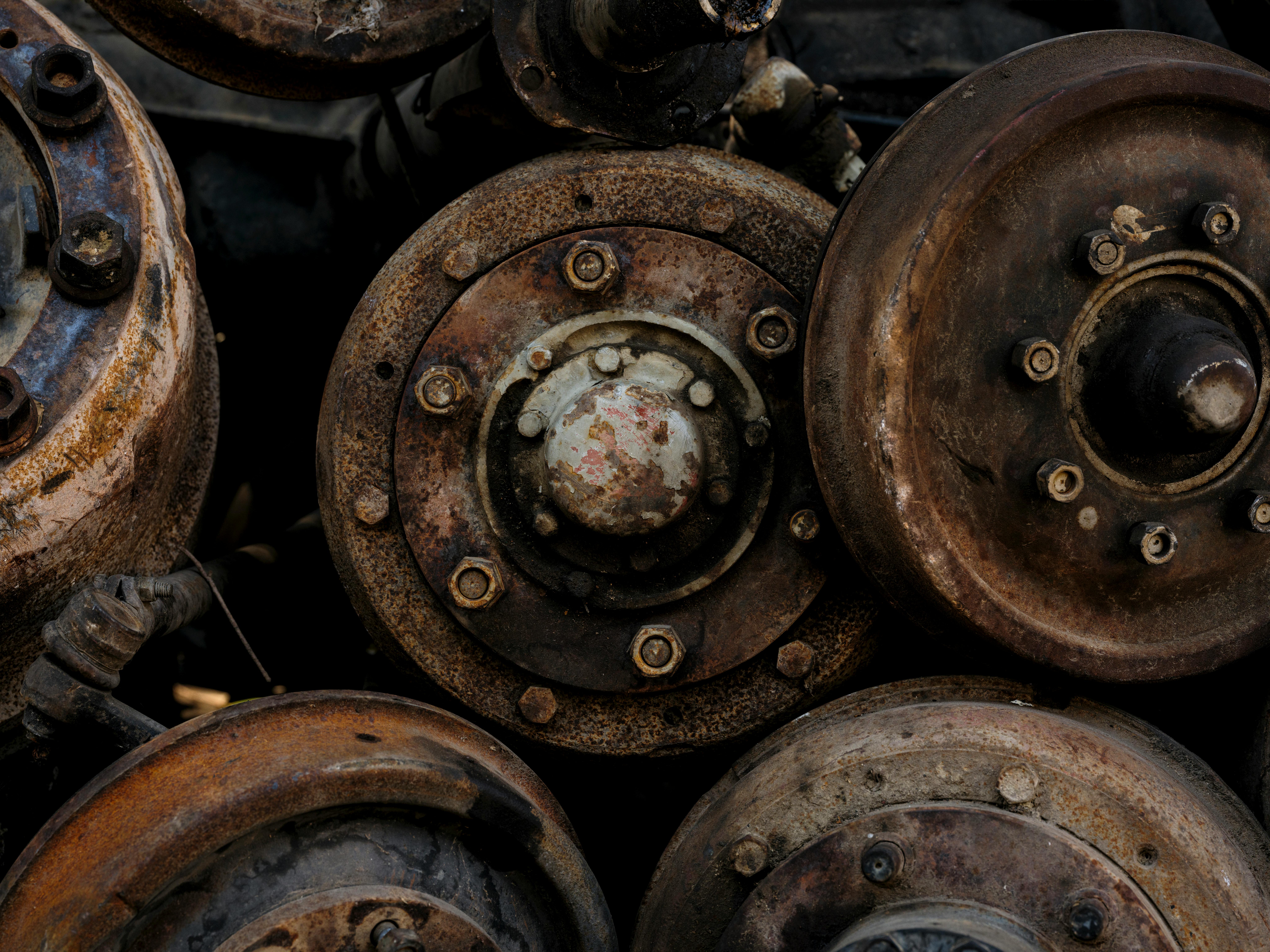 Closeup of rusty, abandoned car parts showcasing decay and vintage industrial elements.
