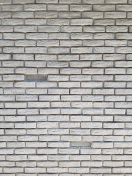 Captured closeup of a weathered white brick wall showcasing vintage texture and pattern.