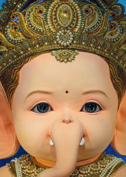 Free A detailed close-up of a beautifully adorned Ganesh idol featuring a magnificent crown. Stock Photo