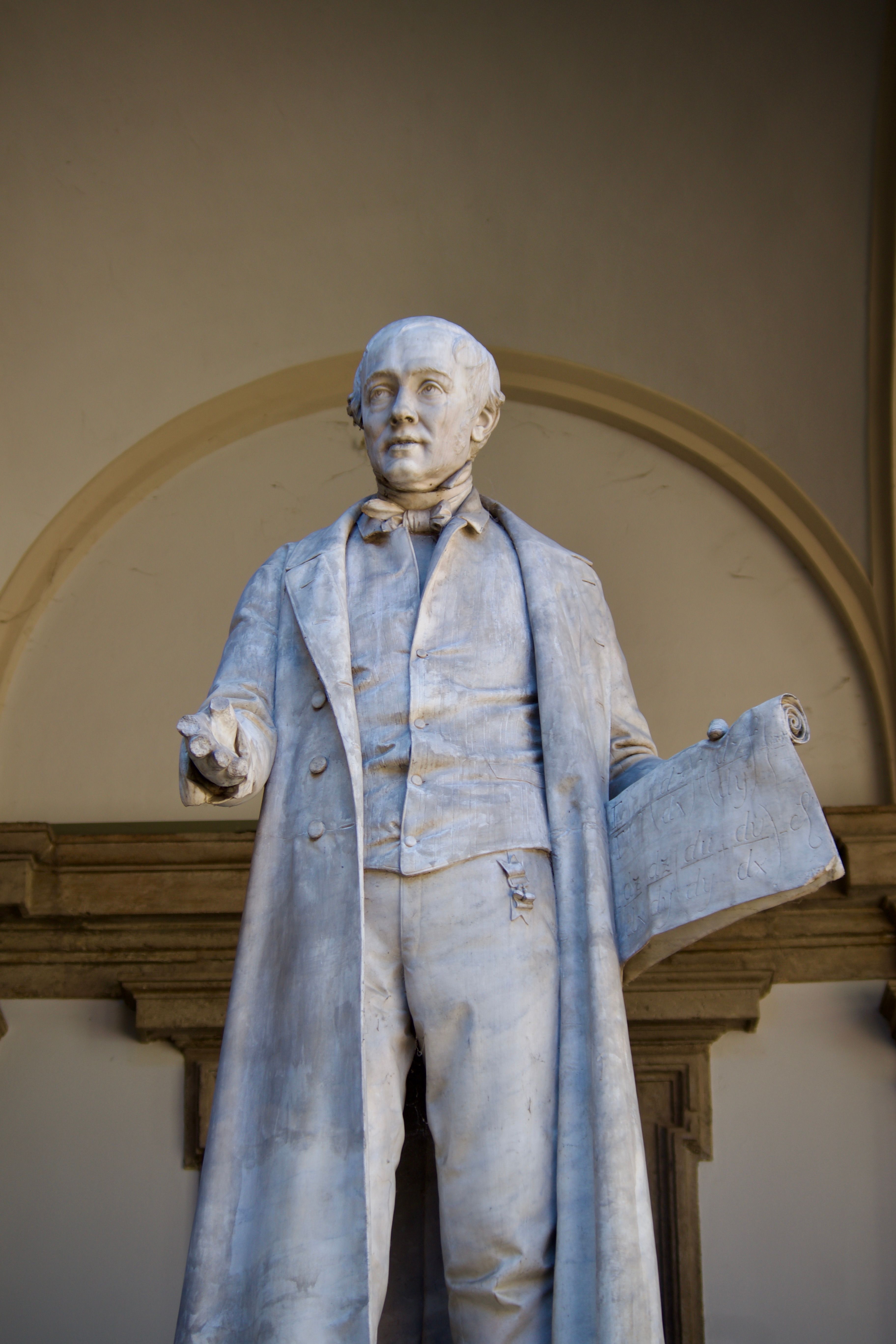 Elegant marble statue of a historical figure in an indoor setting, showcasing fine craftsmanship.