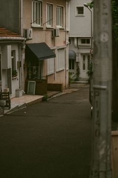 A quiet, empty city alleyway with residential buildings lining both sides.